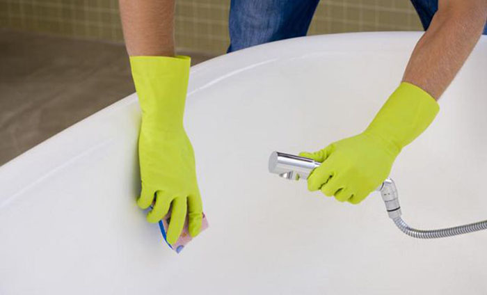 Hands cleaning bathtub