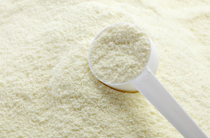 close up of powdered milk and spoon for baby on white background with clipping path